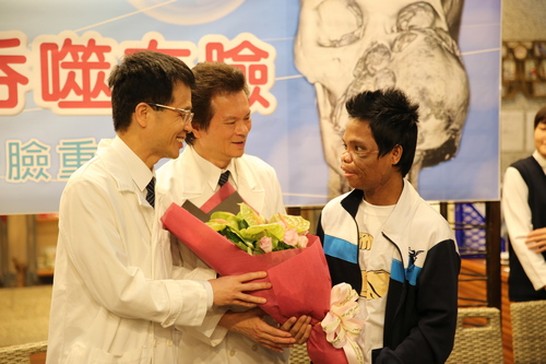 在花蓮慈濟醫院經歷四個月、九次的手術治療後，終於可以回復面容出院，這天麥可準備了鮮花感謝為他移除腫瘤的陳培榕副院長(左一)與為他臉部重建的整形既重建外科主任李俊達(中)讓他重生