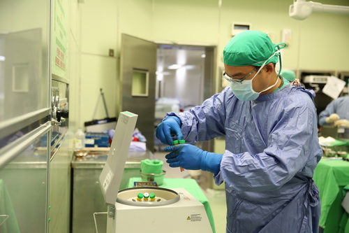 運動醫學中心主任劉冠麟將抽取出的脂肪放入離心機裡