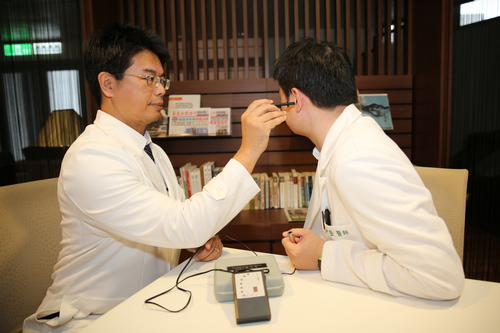 花蓮慈院何宗融副院長(左)示範中醫耳穴健檢
