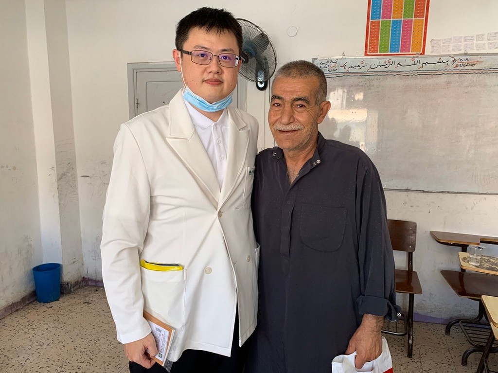 花蓮慈院中醫教育中心副主任陳中奎（左），以針灸緩解敘利亞難民長久以來的痠痛問題，讓病人很開心。