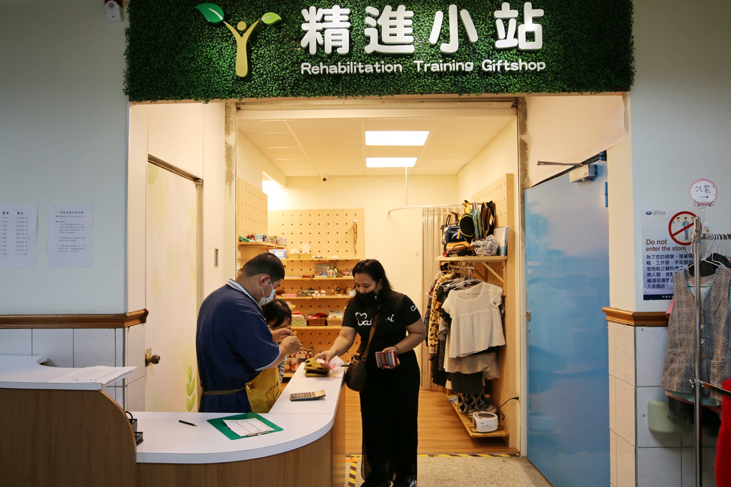 精進小站草綠色的招牌上有象徵「新芽」的圖騰,代表著眾人的愛心灌溉下,學員們的人生旅程也可以持續成長茁壯;內部則是增加了舒適的試衣間,以及暖色調的木櫃,擺放學員們精心製作的手工藝品及二手衣物 精進小站草綠色的招牌上有象徵「新芽」的圖騰,代表著眾人的愛心灌溉下,學員們的人生旅程也可以持續成長茁壯;內部則是增加了舒適的試衣間,以及暖色調的木櫃,擺放學員們精心製作的手工藝品及二手衣物