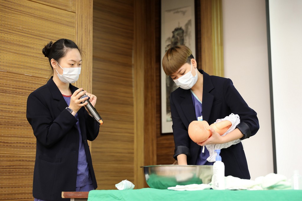 花蓮慈院護兒中心護理師曹雅晴(左)與團隊，帶著爸爸、媽媽一起練習幫寶寶沐浴