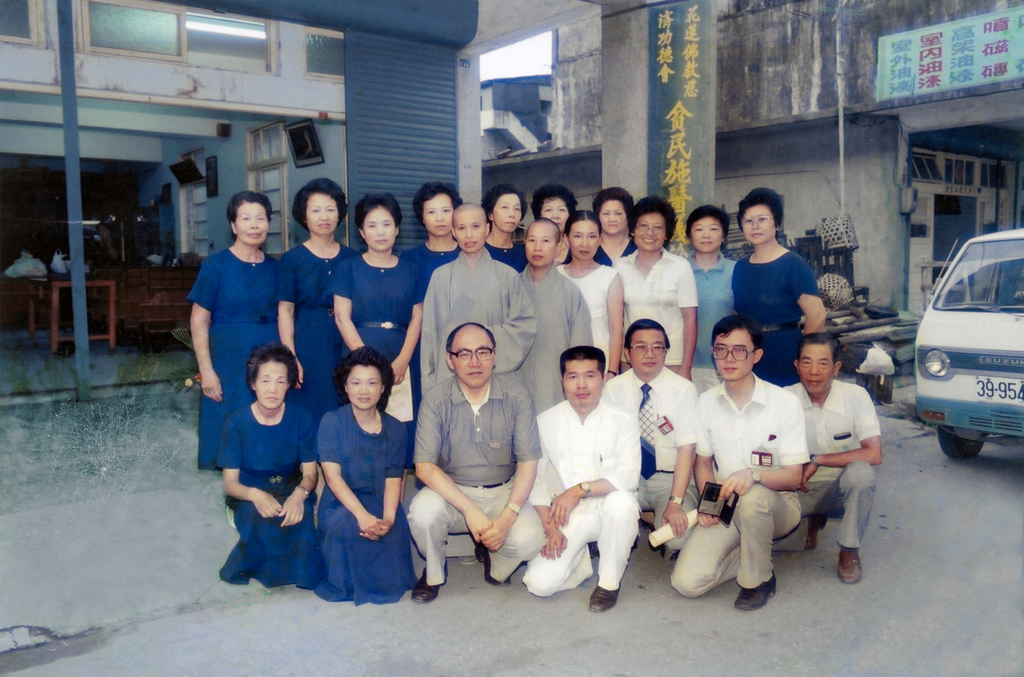 曾文賓院長(前排左三)在仁愛街慈濟義診所前，與來自花蓮慈院的義診醫師、證嚴法師(後排左五)及慈濟志工合影