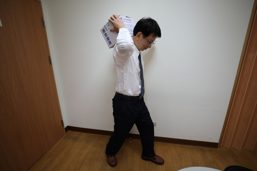 花蓮慈院職業醫學科主治醫師林純吉診間為病人進行評估，並示範常見的扛運重物錯誤動作