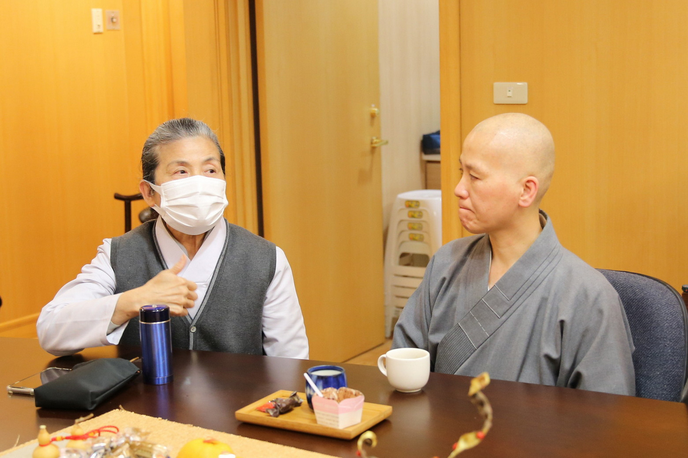 資深志工顏靜曦師姊（左）分享，醫療志工從靜思精舍搭乘交通車到醫院的短短十五分鐘的車程，就是他們的讀書會。由各區前來的志工領隊整理當日在靜思晨語、志工早會所聆聽到的法語來複習外，在這車程中每位志工也會透過分享，加深印象，法也更入心。