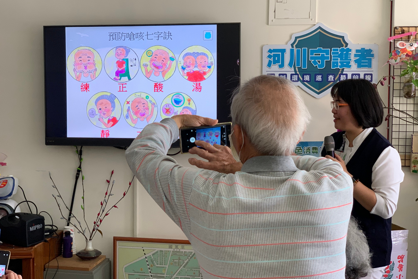 社區據點長輩不斷拿起手機紀錄護理師傳授的秘訣，其中最引起長輩共鳴的就是「要用碗喝水」。