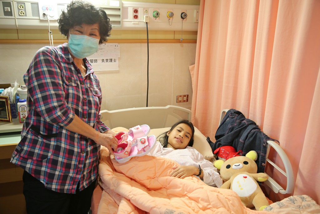 將小班克認做乾孫女的翻譯志工黃志英（左），打從心底疼愛小班克黃志英特別買了一雙粉色蘋果涼鞋送給小班克，祝福她往後的日子「安安穩穩、平平安安」。