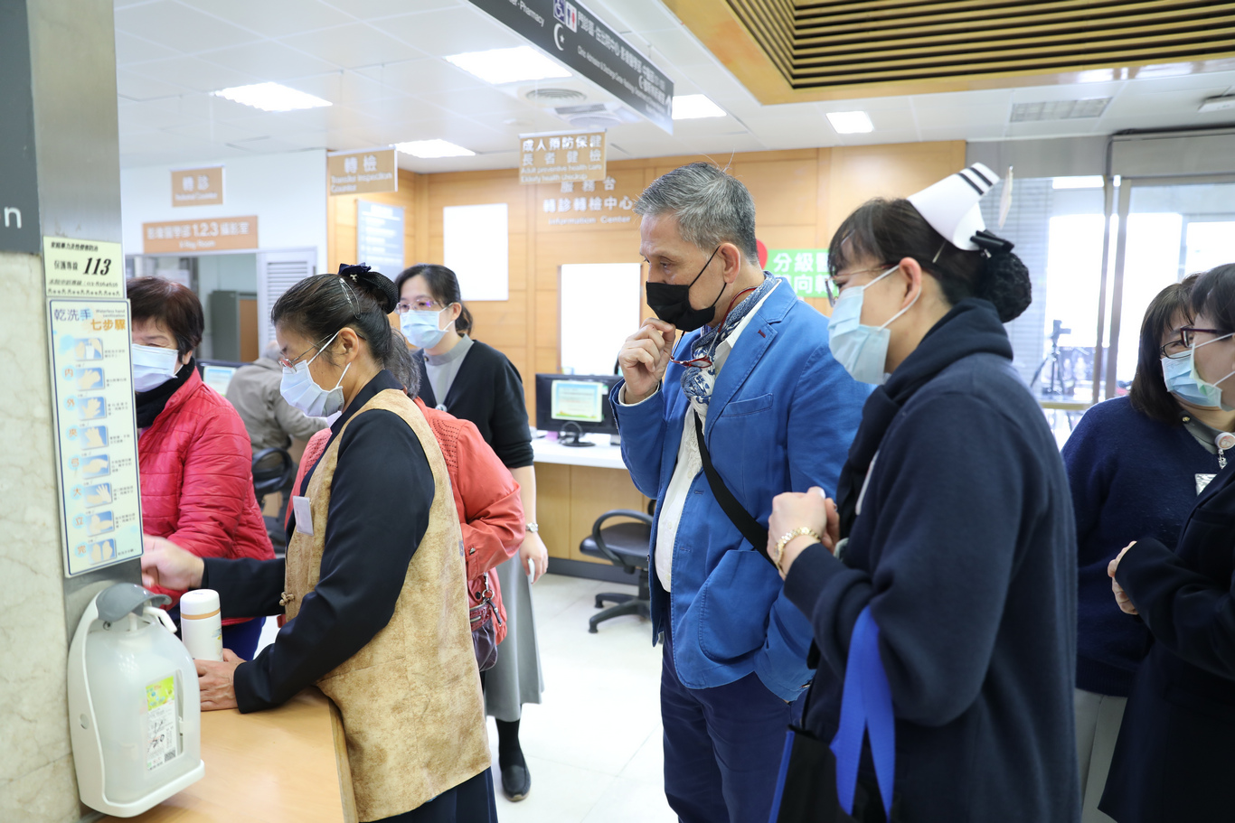 蘇國垚在門診大廳觀察志工及藥劑師與民眾的互動情形。