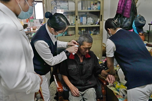 個管師謝樹蘭親切為許先生量體溫。