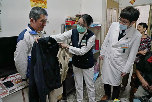 謝樹蘭個管師貼心的拿出許副院長的外套，讓許哥哥比對是否合身。