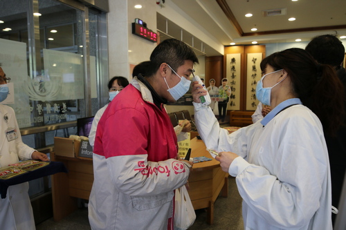 從二十九日開始，百位行政單位同仁也加入門禁管制值勤行列，每天排定十六個班次、動員五十人次，在入口處的冷風中，和醫療志工們協力同心，一併扛起防疫任務