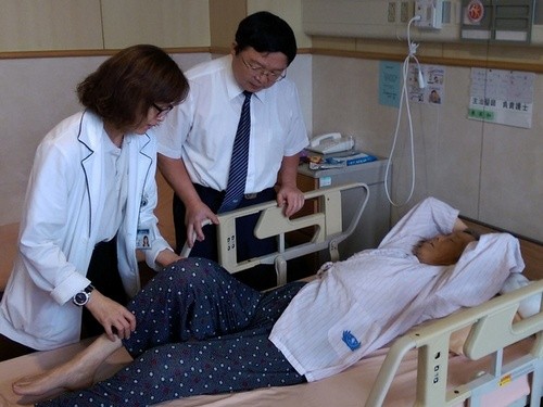 陳英和名譽院長(中)和物理治療師黃貞茹(左)為孫女士進行復健。