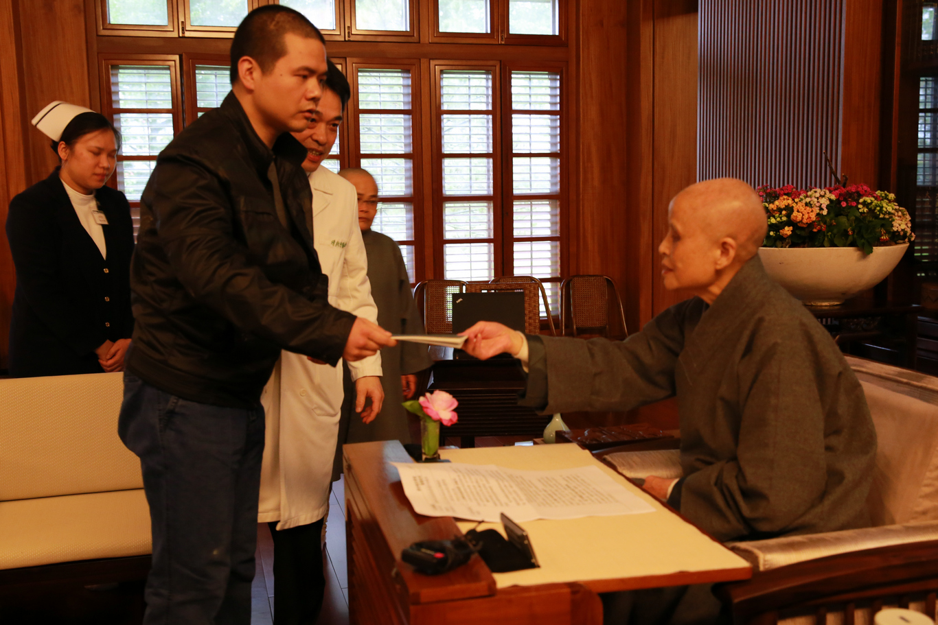 吳曉冬送上自己手術後利用空閒時間手抄的心經，向　上人展現復健成果