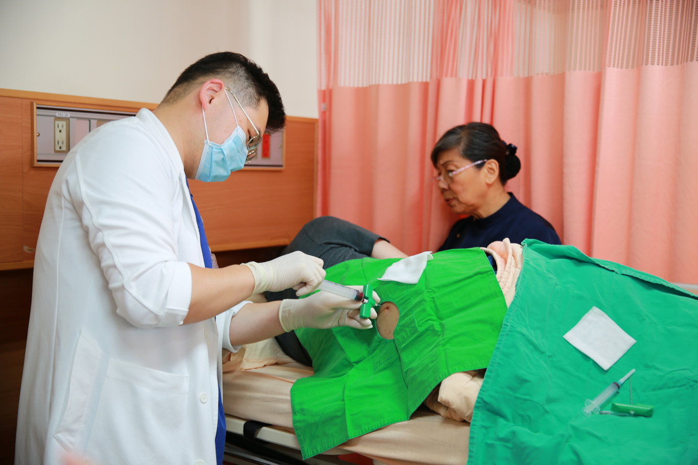 血液腫瘤科黃威翰醫師為Martin抽骨髓檢查。（彭薇勻攝）