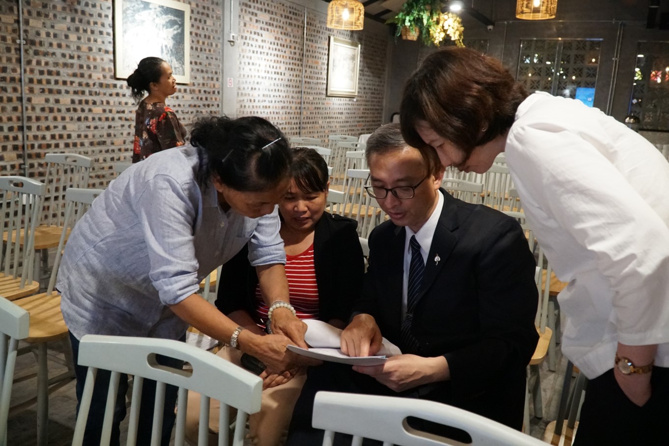 左圖：白小弟母親(左二)特地從順化搭機來河內，攜帶白小弟病歷在講座開始前請教李醫師(右二)。不捨小弟病情，返台後，李醫師呼籲救助小弟，獲得熱烈響應。